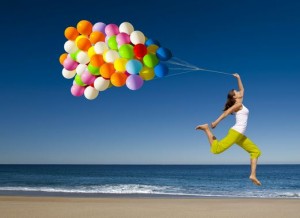 Woman at Beach Jumping with Balloons