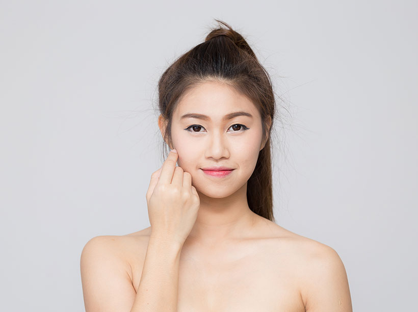 woman looking at camera with a hand on her face