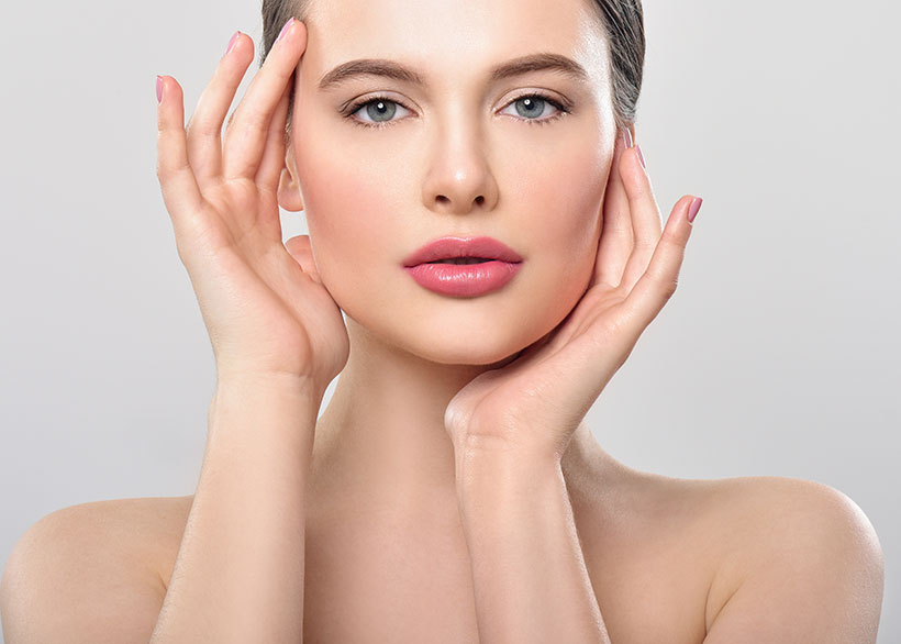woman looking at camera with her hands on her face
